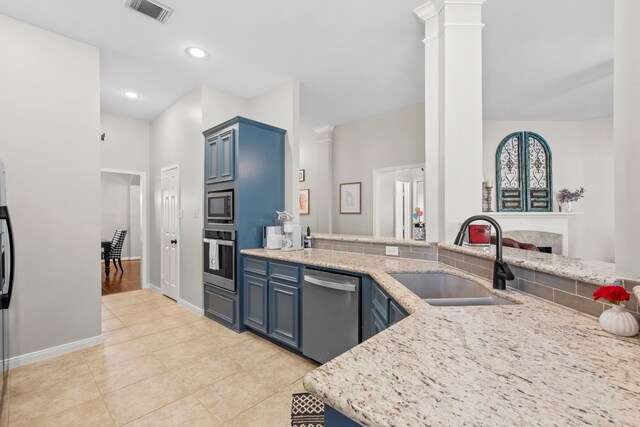 14123 Sherburn Manor Dr, Cypress, TX 77429 - kitchen featuring a sink, stainless steel appliances, blue cabinetry, baseboards, and ornate columns