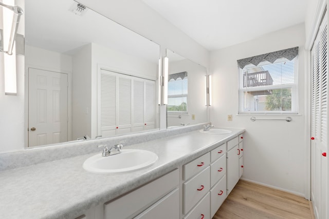 4209 W Bayside Way, Jamaica Beach, TX 77554 - full bathroom featuring wood finished floors, healthy amount of natural light, double vanity, and baseboards