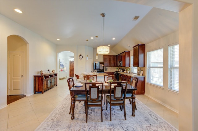 19503 Sundance Edge Ct, Richmond, TX 77407 - dining space with arched walkways, light tile patterned flooring, recessed lighting, baseboards, and vaulted ceiling