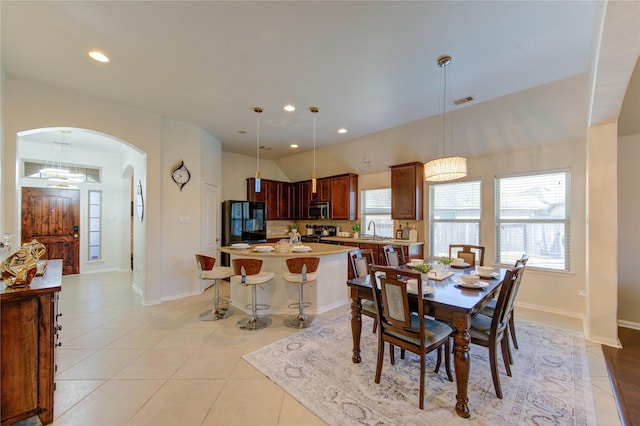 19503 Sundance Edge Ct, Richmond, TX 77407 - dining area with arched walkways, light tile patterned floors, recessed lighting, and baseboards