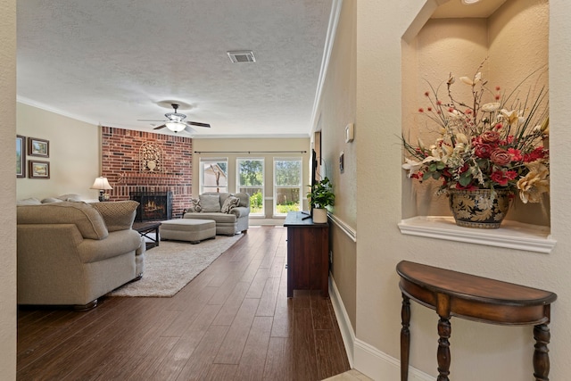 13506 Scenic Glade Dr, Houston, TX 77059 - living area featuring a fireplace, a ceiling fan, ornamental molding, dark wood finished floors, and a textured ceiling
