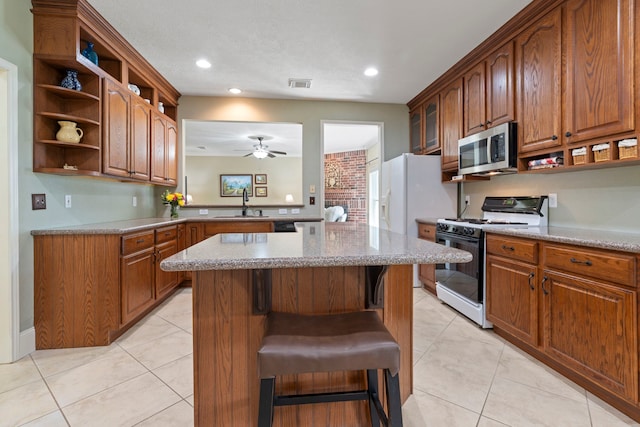 13506 Scenic Glade Dr, Houston, TX 77059 - kitchen with gas stove, stainless steel microwave, a sink, open shelves, and a center island