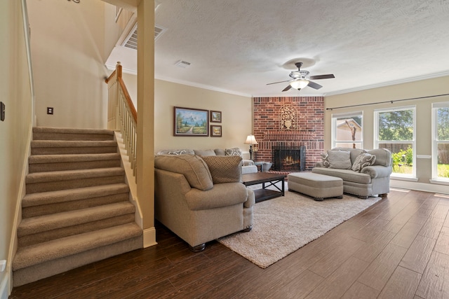 13506 Scenic Glade Dr, Houston, TX 77059 - living room with dark wood-style floors, a ceiling fan, a brick fireplace, stairway, and ornamental molding