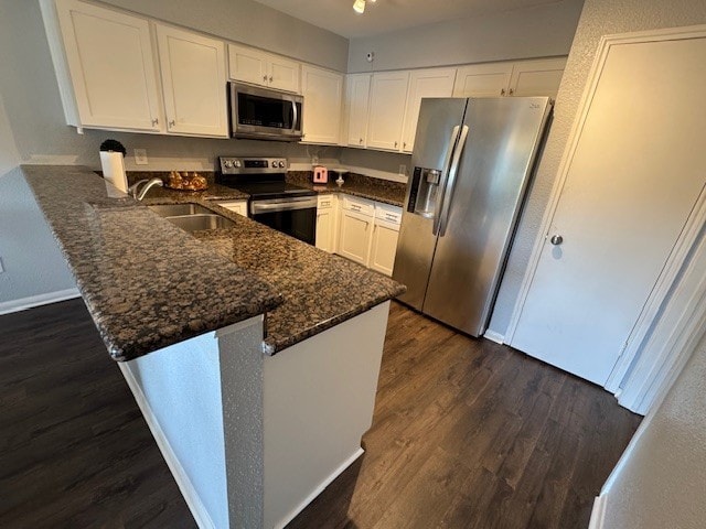 2211 S Kirkwood Rd Unit 1, Houston, TX 77077 - kitchen with appliances with stainless steel finishes, a sink, a peninsula, dark wood-style flooring, and white cabinets