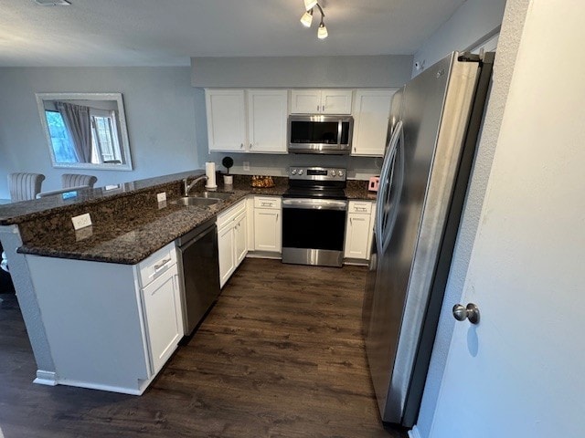 2211 S Kirkwood Rd Unit 1, Houston, TX 77077 - kitchen with appliances with stainless steel finishes, a sink, dark wood-style floors, white cabinets, and a peninsula
