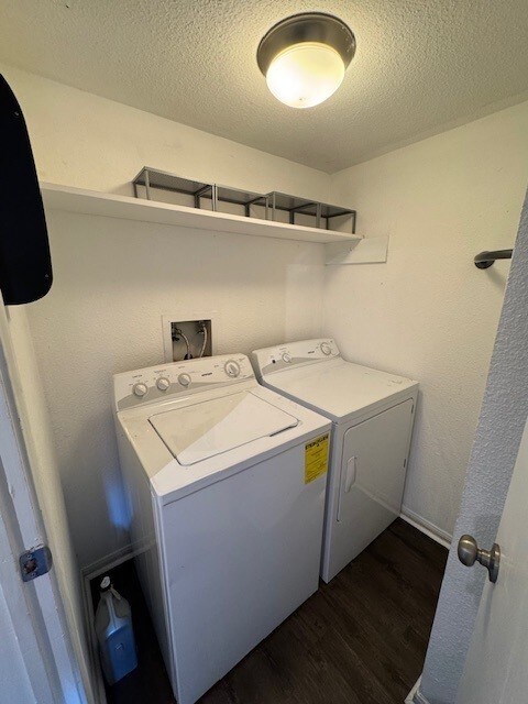 2211 S Kirkwood Rd Unit 1, Houston, TX 77077 - laundry room with washing machine and clothes dryer, dark wood-style flooring, and a textured ceiling