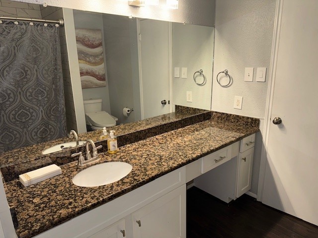 2211 S Kirkwood Rd Unit 1, Houston, TX 77077 - full bath with wood finished floors, vanity, curtained shower, and a textured wall