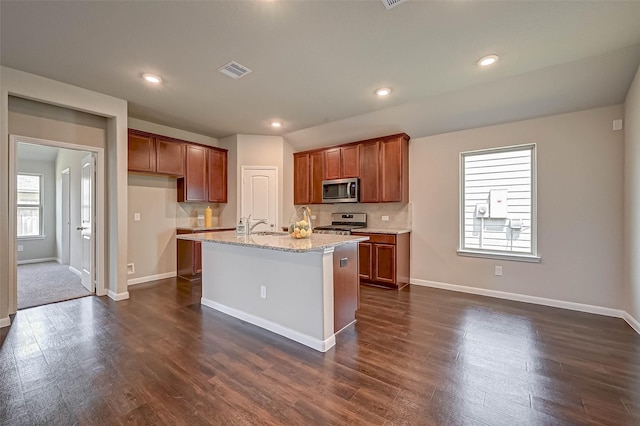 21622 Sage Landing Ln, Katy, TX 77449 - kitchen with stainless steel appliances, dark wood-style floors, baseboards, brown cabinetry, and recessed lighting