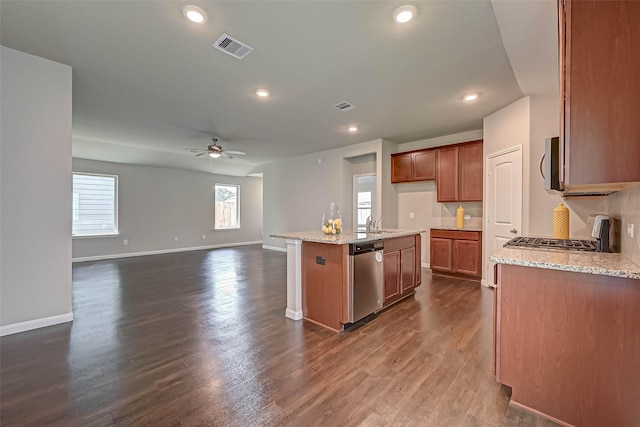 21622 Sage Landing Ln, Katy, TX 77449 - kitchen with stainless steel appliances, a ceiling fan, baseboards, light stone counters, and recessed lighting