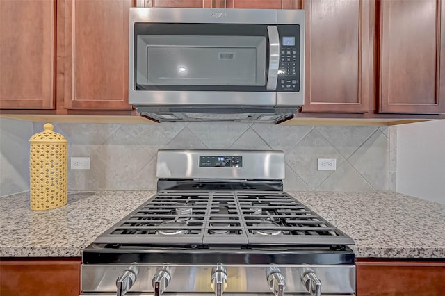 21622 Sage Landing Ln, Katy, TX 77449 - kitchen featuring stainless steel appliances, tasteful backsplash, and light stone counters