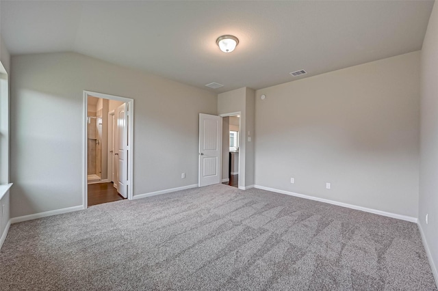 21622 Sage Landing Ln, Katy, TX 77449 - unfurnished bedroom featuring dark carpet, baseboards, lofted ceiling, and ensuite bath