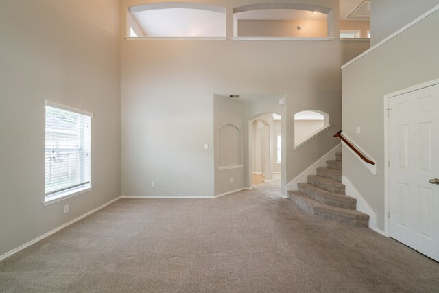 20107 Louetta Crossing Dr, Spring, TX 77388 - entryway with a high ceiling, carpet flooring, arched walkways, stairs, and baseboards