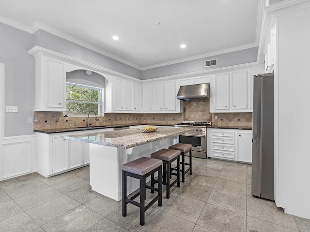 13 Hickory Shadows Dr, Houston, TX 77055 - kitchen with stainless steel appliances, under cabinet range hood, a sink, white cabinets, and a center island