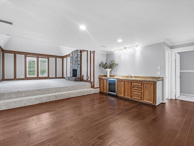 13 Hickory Shadows Dr, Houston, TX 77055 - kitchen featuring wine cooler, ornamental molding, brown cabinetry, a brick fireplace, and dark wood-type flooring