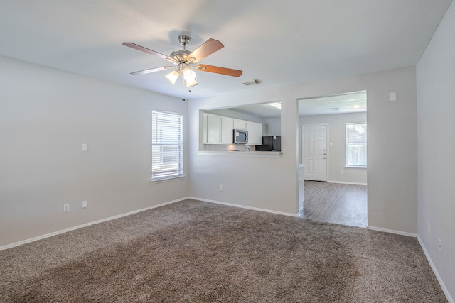 21002 Brannon Hill Ln, Humble, TX 77338 - unfurnished living room featuring carpet flooring, baseboards, and a ceiling fan