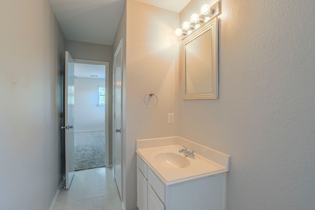 21002 Brannon Hill Ln, Humble, TX 77338 - bathroom with vanity, baseboards, a textured wall, and tile patterned flooring
