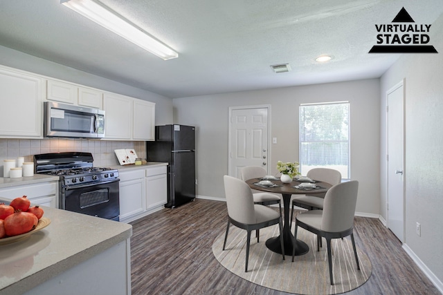 21002 Brannon Hill Ln, Humble, TX 77338 - kitchen featuring black appliances, dark wood-style floors, backsplash, white cabinets, and baseboards