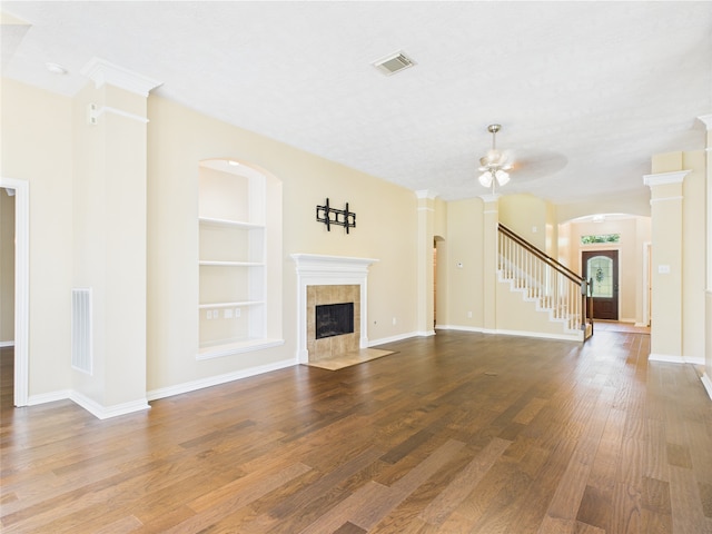 11628 King Edward Ct, Montgomery, TX 77316 - unfurnished living room with built in shelves, wood finished floors, a tile fireplace, and baseboards
