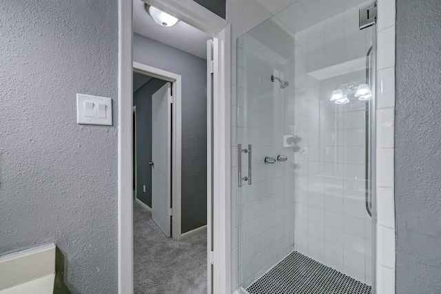 full bath with a shower stall and a textured wall