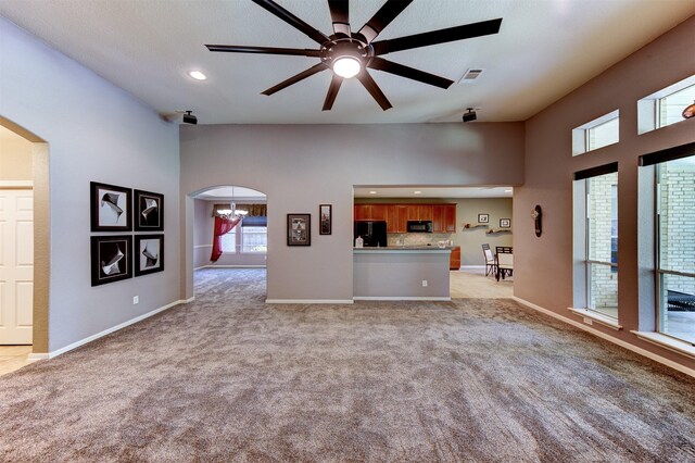 1810 Spreading Bough Ln, Richmond, TX 77406 - unfurnished living room with arched walkways, ceiling fan, light colored carpet, baseboards, and a high ceiling