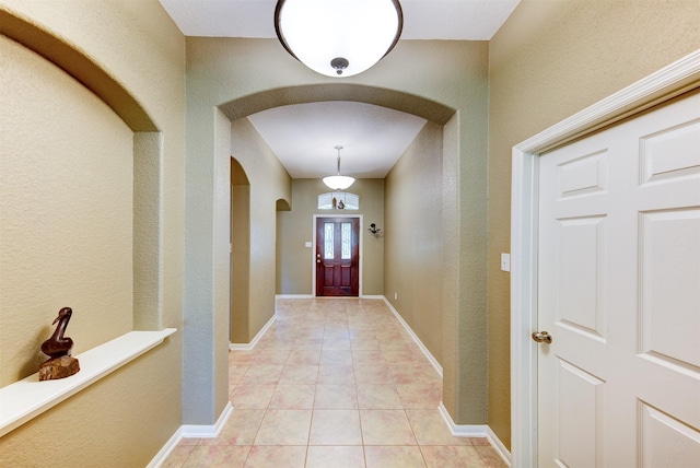 1810 Spreading Bough Ln, Richmond, TX 77406 - entrance foyer featuring arched walkways, a textured wall, and light tile patterned floors