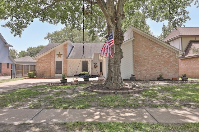 mid-century home featuring brick siding, a shingled roof, and fence