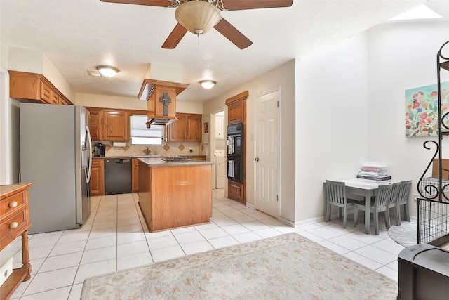 kitchen featuring black appliances, a center island, tasteful backsplash, light tile patterned floors, and brown cabinetry