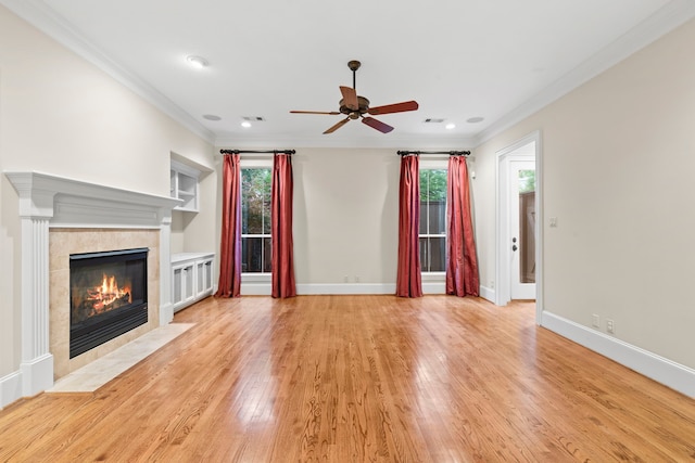 6230 Elm Heights Ln, Houston, TX 77081 - unfurnished living room featuring ornamental molding, a ceiling fan, healthy amount of natural light, light wood-type flooring, and a tile fireplace