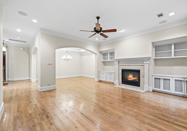 6230 Elm Heights Ln, Houston, TX 77081 - unfurnished living room featuring crown molding, a ceiling fan, arched walkways, light wood finished floors, and a fireplace