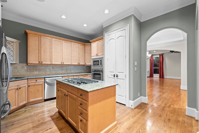 6230 Elm Heights Ln, Houston, TX 77081 - kitchen featuring appliances with stainless steel finishes, crown molding, light brown cabinets, a kitchen island, and backsplash