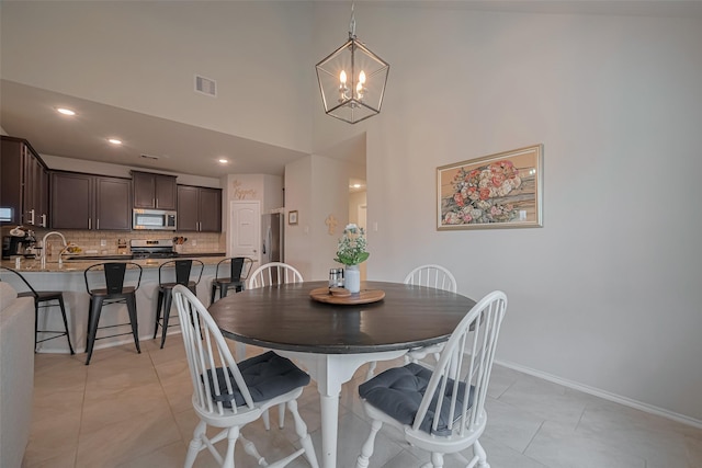 4523 Stolz Trl, Katy, TX 77493 - dining room with a chandelier, light tile patterned floors, a high ceiling, baseboards, and recessed lighting