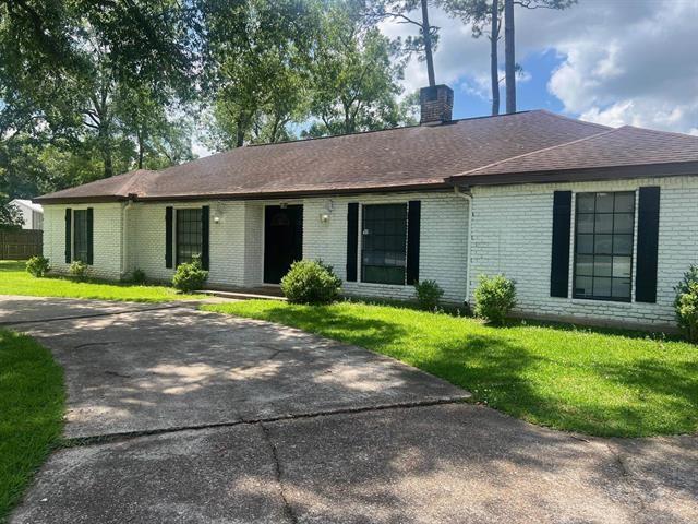 13375 Craig Ln, Bevil Oaks, TX 77713 - ranch-style home with brick siding, a chimney, a front yard, and a shingled roof