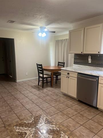 13375 Craig Ln, Bevil Oaks, TX 77713 - kitchen with stainless steel dishwasher, ornamental molding, light tile patterned floors, ceiling fan, and baseboards