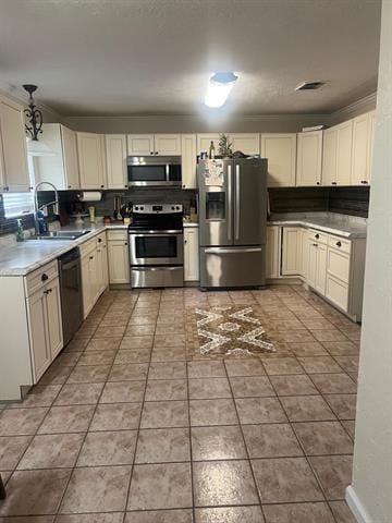 13375 Craig Ln, Bevil Oaks, TX 77713 - kitchen with stainless steel appliances, a sink, light countertops, hanging light fixtures, and tile patterned flooring