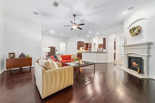 27259 Jessica Hills Ln, Spring, TX 77386 - living area with arched walkways, a ceiling fan, a glass covered fireplace, dark wood finished floors, and recessed lighting