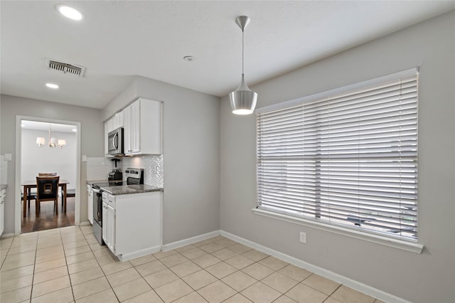 19411 Southaven Dr, Houston, TX 77084 - kitchen with stainless steel appliances, white cabinetry, pendant lighting, baseboards, and a chandelier