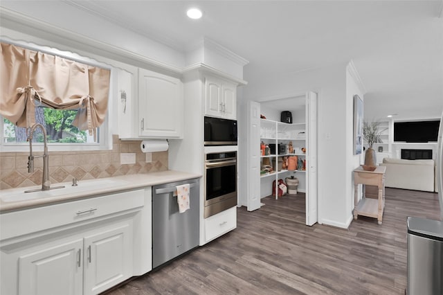 16419 Fox Crossing Ln, Spring, TX 77379 - kitchen with appliances with stainless steel finishes, a sink, white cabinetry, decorative backsplash, and light countertops