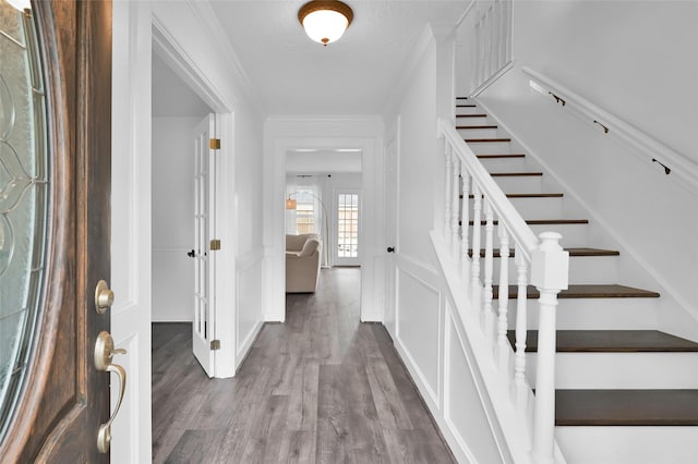 16419 Fox Crossing Ln, Spring, TX 77379 - foyer featuring wood finished floors, stairs, ornamental molding, a decorative wall, and a wainscoted wall