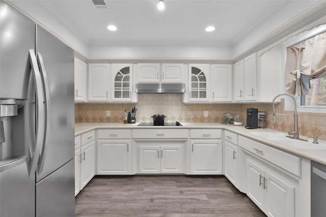 16419 Fox Crossing Ln, Spring, TX 77379 - kitchen featuring stainless steel appliances, a sink, under cabinet range hood, glass insert cabinets, and white cabinetry