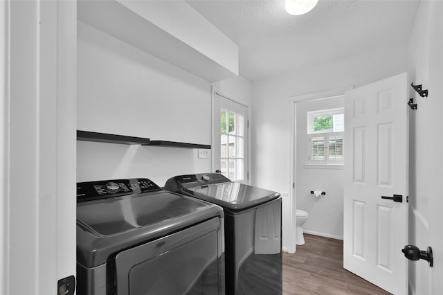 16419 Fox Crossing Ln, Spring, TX 77379 - washroom featuring washer and dryer, wood finished floors, baseboards, and a textured ceiling