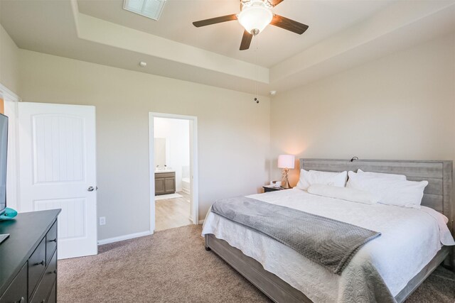14657 E Pine Heart Dr, Conroe, TX 77302 - bedroom with a tray ceiling, light colored carpet, baseboards, and ensuite bathroom