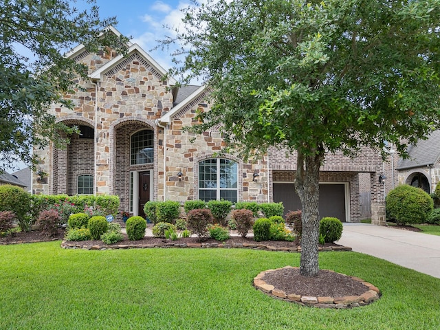 2322 Dolan Springs Ln, Friendswood, TX 77546 - french provincial home with concrete driveway, a front yard, stone siding, and brick siding