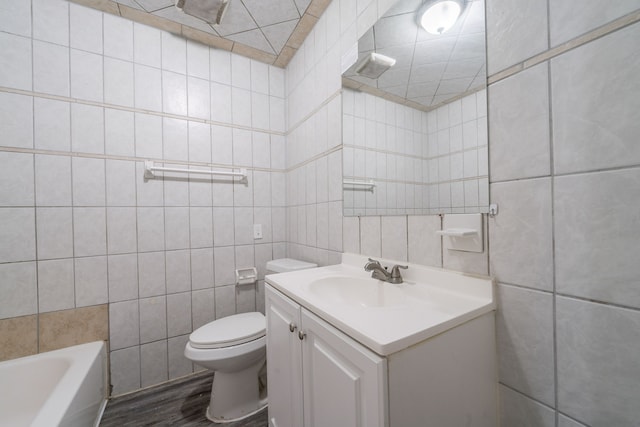 751 Terryhollow St, Channelview, TX 77530 - bathroom featuring tile walls, toilet, vanity, a tub, and wood finished floors