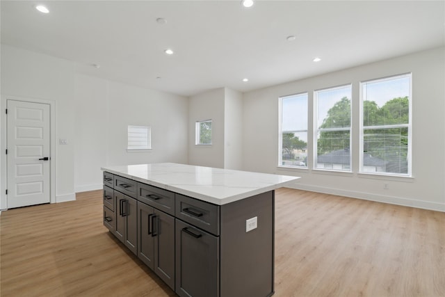4629 Balkin St, Houston, TX 77021 - kitchen featuring light wood-style floors, a kitchen island, baseboards, recessed lighting, and light stone counters