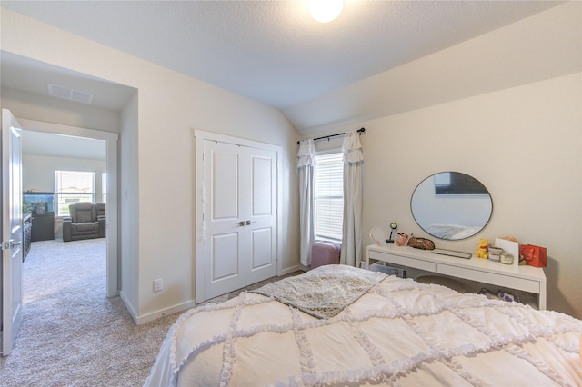 3033 Myrtle Sunset Dr, Katy, TX 77493 - bedroom with multiple windows, carpet flooring, vaulted ceiling, a closet, and baseboards