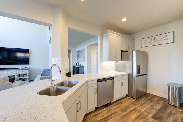 3033 Myrtle Sunset Dr, Katy, TX 77493 - kitchen with appliances with stainless steel finishes, a sink, dark wood-style floors, light stone counters, and open floor plan