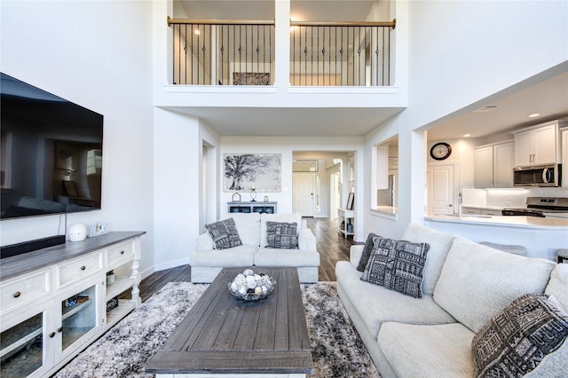 3033 Myrtle Sunset Dr, Katy, TX 77493 - living area featuring baseboards, a towering ceiling, and wood finished floors