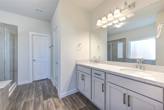 3033 Myrtle Sunset Dr, Katy, TX 77493 - bathroom with a shower stall, double vanity, wood finished floors, and baseboards