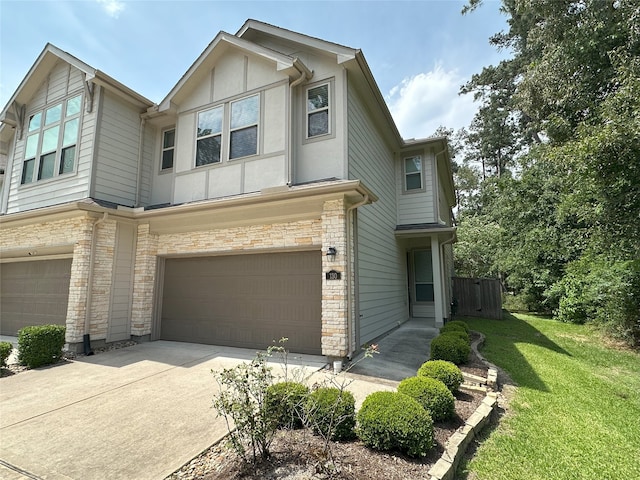 130 Moon Dance Ct, Conroe, TX 77304 - townhome / multi-family property featuring a garage, a front lawn, stone siding, driveway, and stucco siding