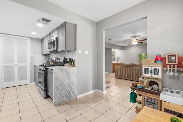 3623 Wells Mark Dr, Humble, TX 77396 - kitchen with appliances with stainless steel finishes, gray cabinetry, light tile patterned floors, light countertops, and backsplash